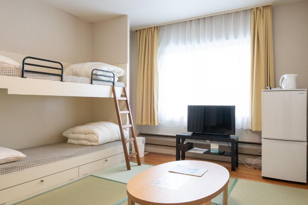 a small room with bunk beds and a table at Angel Resort Yuzawa / Vacation STAY 7045 in Yuzawa