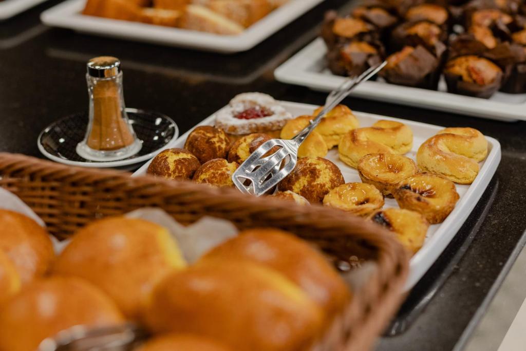 Pastries and breads are arranged on a breakfast buffet counter.