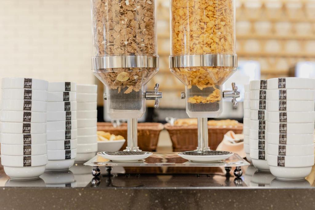 Cereal dispensers stand between stacks of breakfast cups and bowls.