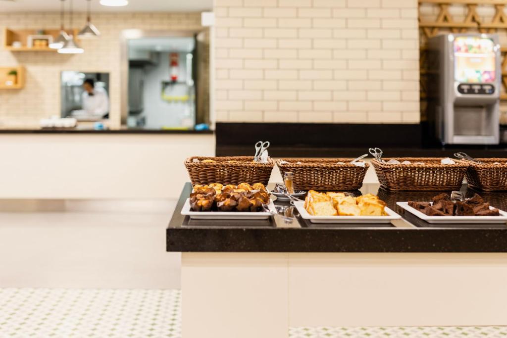 A self-service counter holds baskets and trays of pastries and cake.