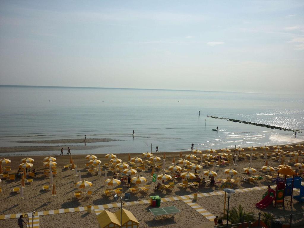 una spiaggia con un mucchio di ombrelloni e l'oceano di Hotel Oasi Ristorante Pizzeria a Fano