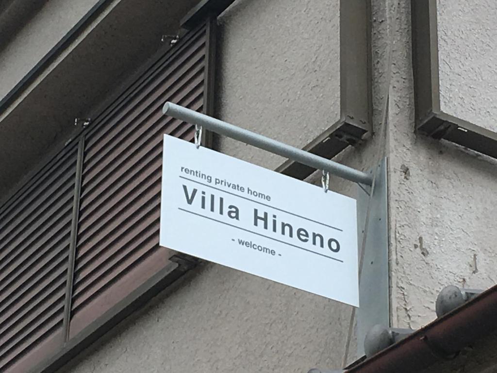 una señal blanca en el lateral de un edificio en Villa Hineno / Vacation STAY 79056 en Izumi-Sano