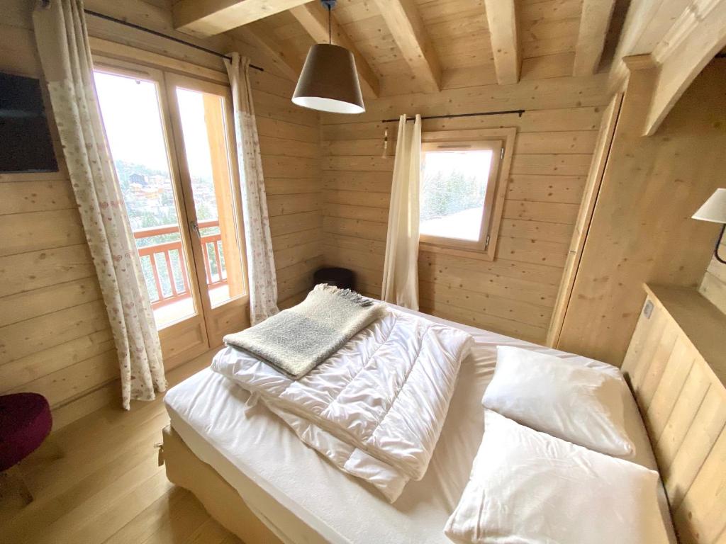 クールシュヴェルにあるles craterellesの木造キャビン内のベッド1台が備わるベッドルーム1室を利用します。