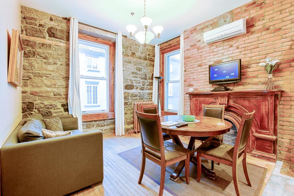 uma sala de estar com uma mesa de madeira e uma televisão em Le Haute Ville em Cidade de Quebec