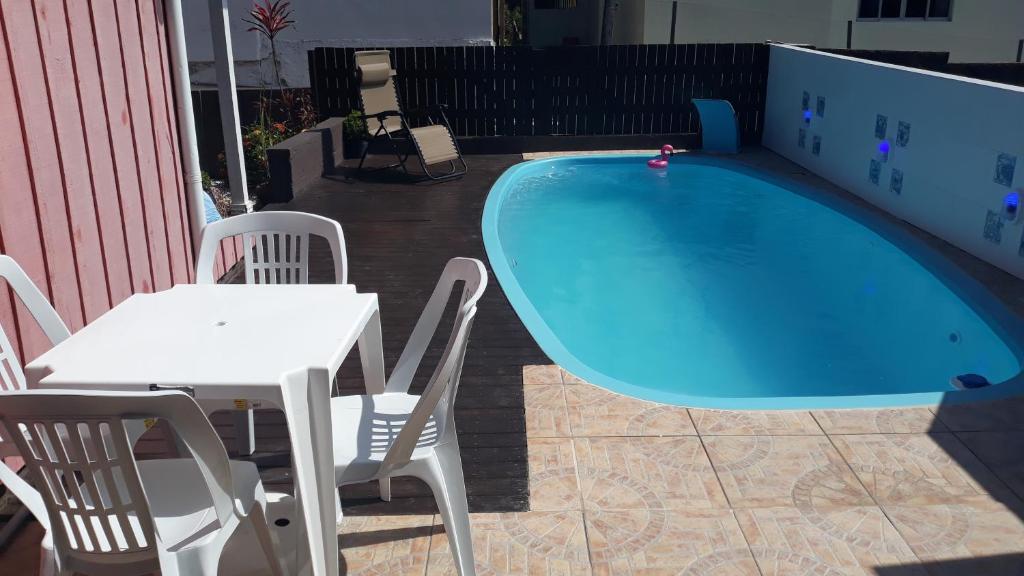 uma mesa e cadeiras ao lado de uma piscina em Casa Ribeirao da Ilha em Florianópolis