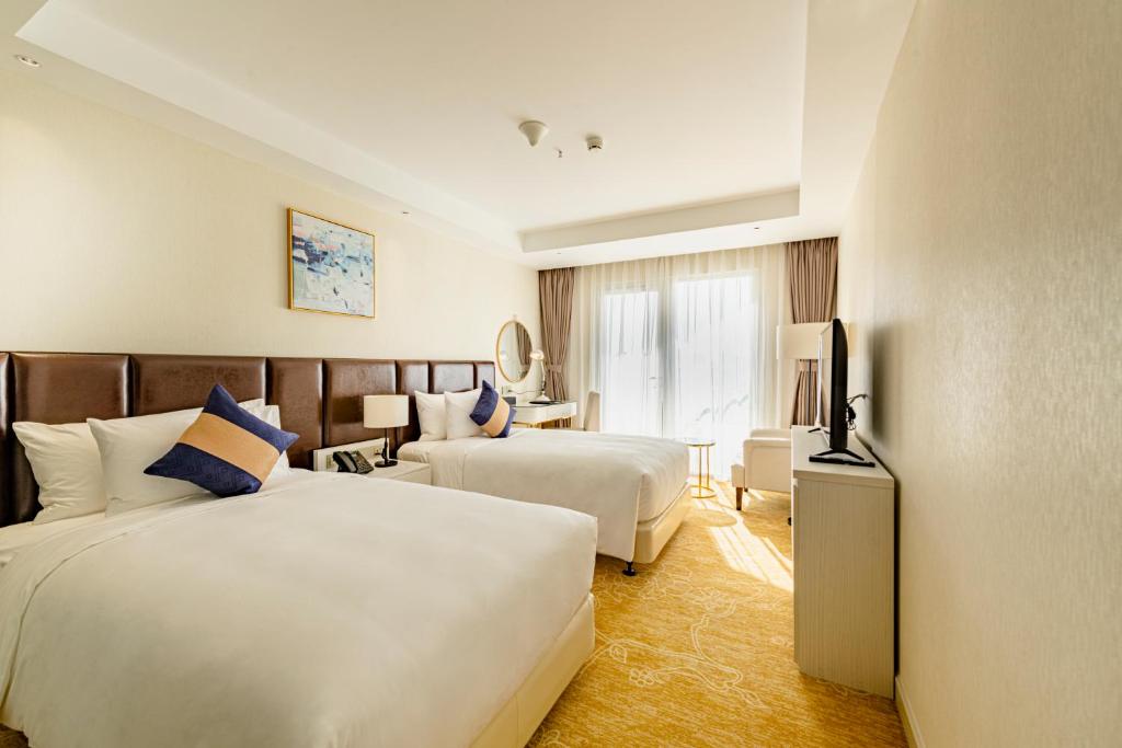 Giường trong phòng chung tại La Vela Saigon Hotel