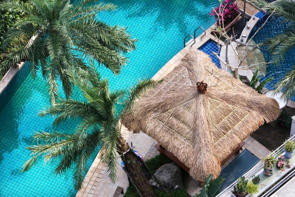 礁溪鄉的住宿－麗翔酒店連鎖-礁溪館，享有带大稻草雨伞的游泳池的顶部景致
