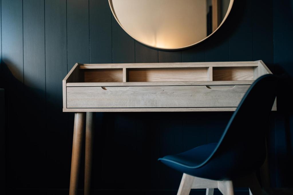 a desk with a mirror and a blue chair at The Fullerton Arms in Ballintoy