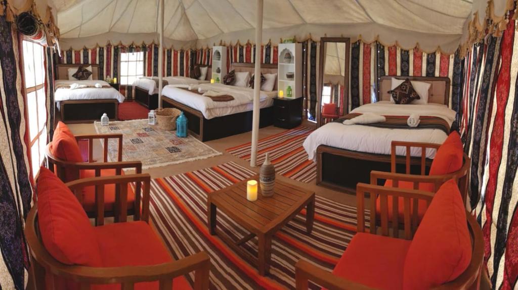 a large room with two beds and a table and chairs at Alsarmadi Desert Camp in Shāhiq