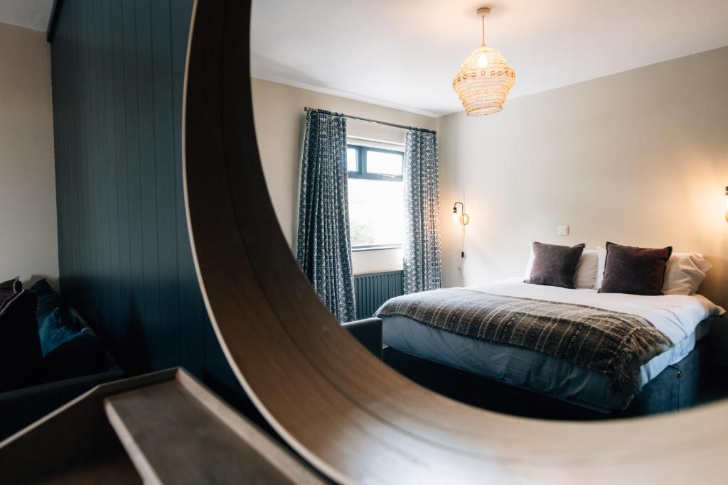 a mirror in a bedroom with a bed and a bed sqor at The Fullerton Arms in Ballintoy