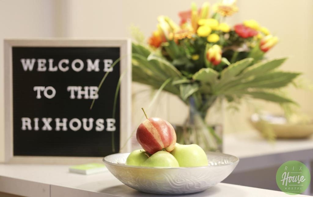 a bowl of apples on a table with a welcome to therak house sign at RixHouse Hostel in Berlin