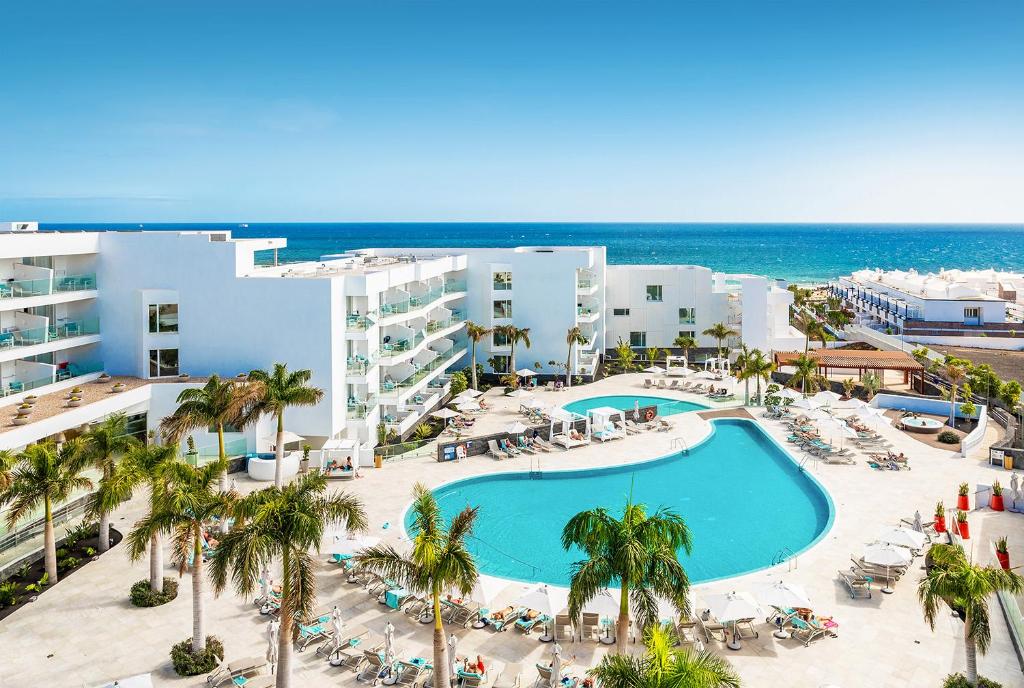 an aerial view of a resort with a pool and the ocean at Hotel Lava Beach in Puerto del Carmen