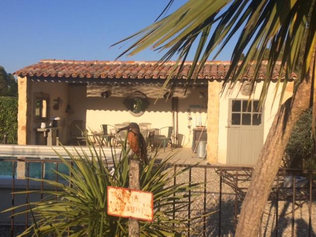 un pájaro parado frente a una casa en Appartement dans Mas Provencal en Grans