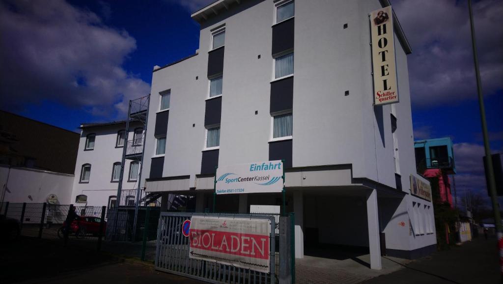 a white building with a sign in front of it at Hotel Schillerquartier in Kassel