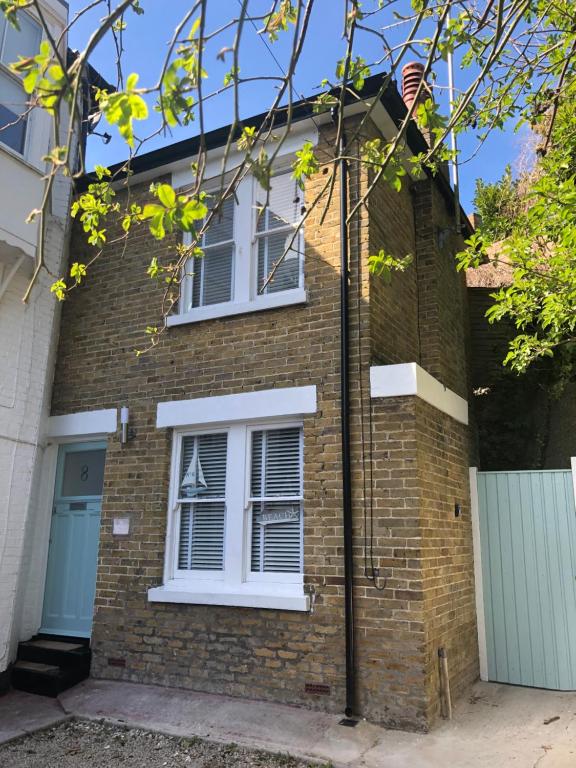 a brick house with white windows and a gate at Seaview Cottage in Broadstairs