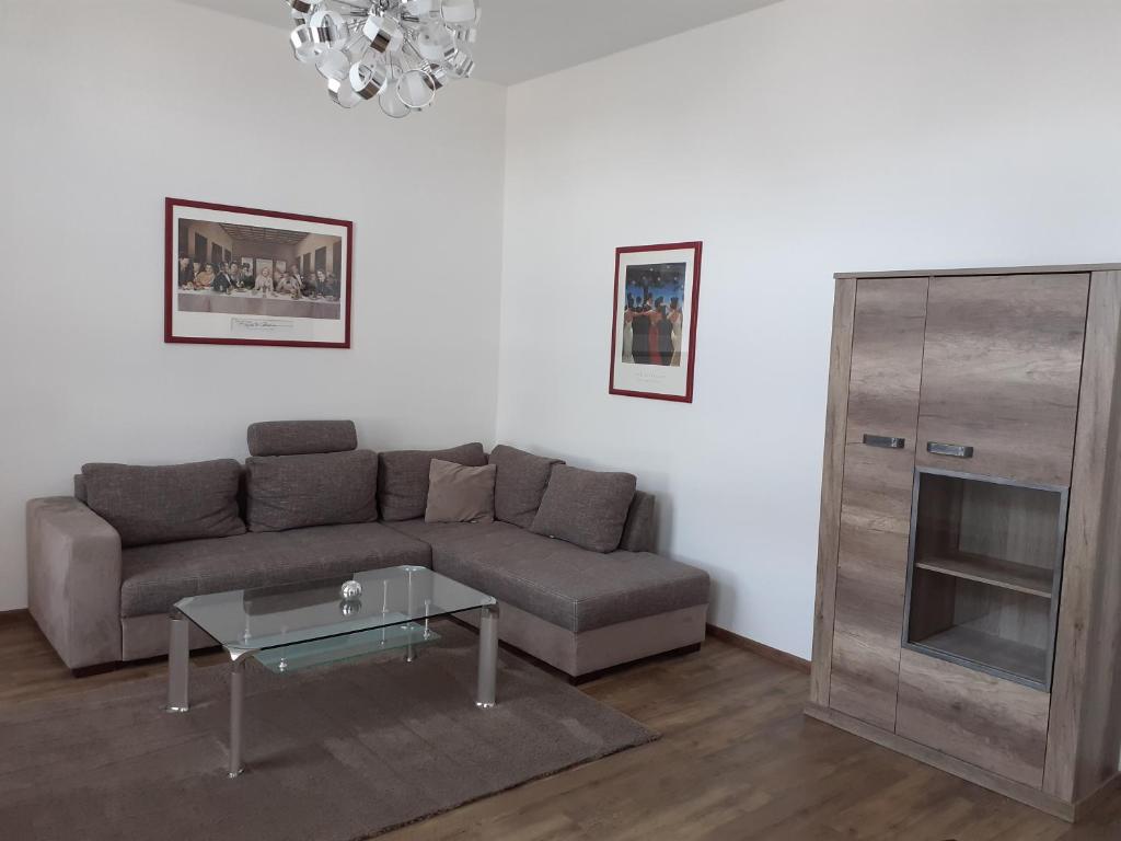 uma sala de estar com um sofá e uma mesa de vidro em Ferienwohnung Angelika em Wilhelmshaven