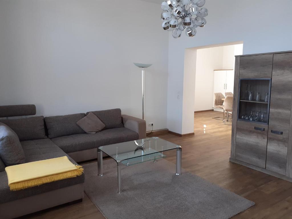 sala de estar con sofá y mesa de cristal en Ferienwohnung Diana, en Wilhelmshaven