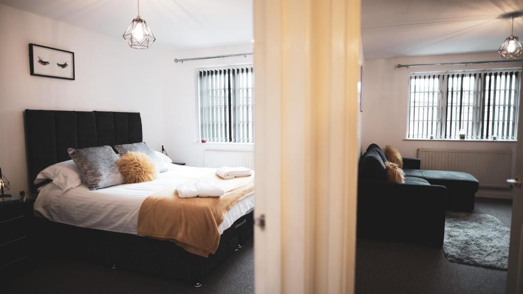 a bedroom with a bed and a couch at Asha Court Serviced Apartments in Worcester