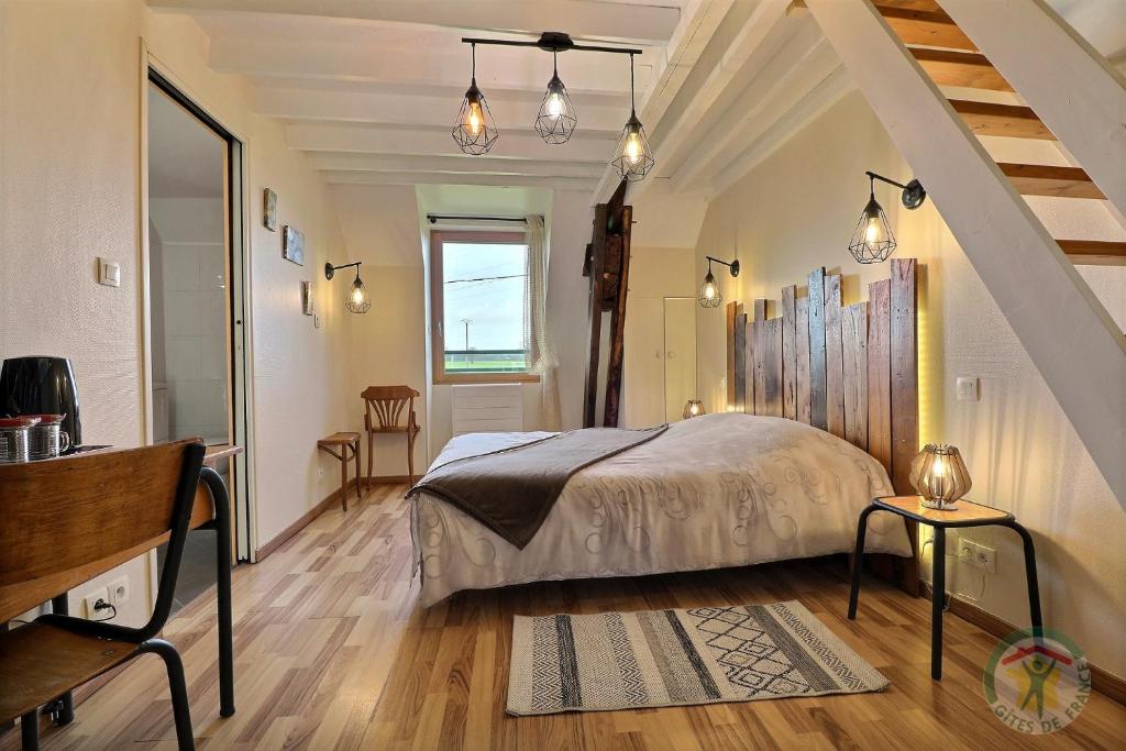 ein Schlafzimmer mit einem großen Bett und einer Treppe in der Unterkunft Chambres D'HÔTES in Vezin-le-Coquet