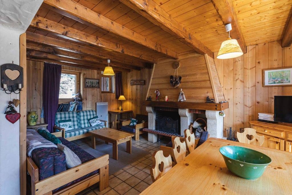 a living room with a fireplace in a log cabin at L'arpont in Champagny-en-Vanoise