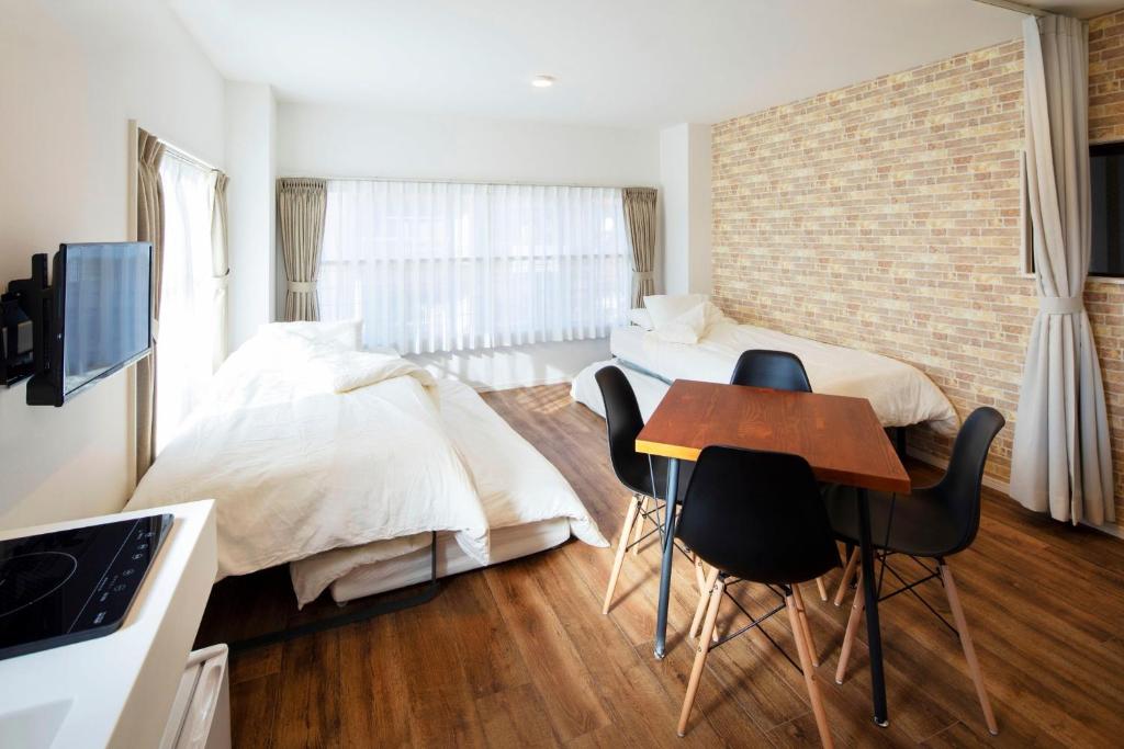 1 dormitorio con 1 cama, mesa y sillas en HOTEL LITTLE BIRD OKU-ASAKUSA / Vacation STAY 79442, en Tokio