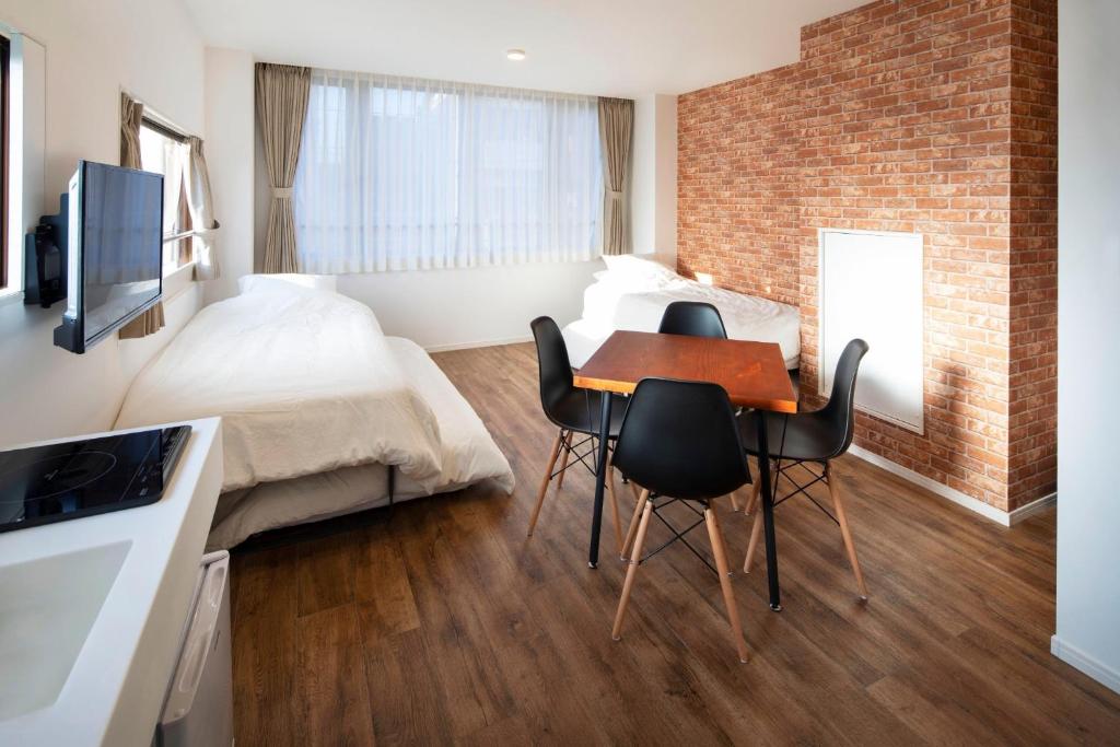 een slaapkamer met een bed en een tafel en stoelen bij HOTEL LITTLE BIRD OKU-ASAKUSA / Vacation STAY 79446 in Tokyo