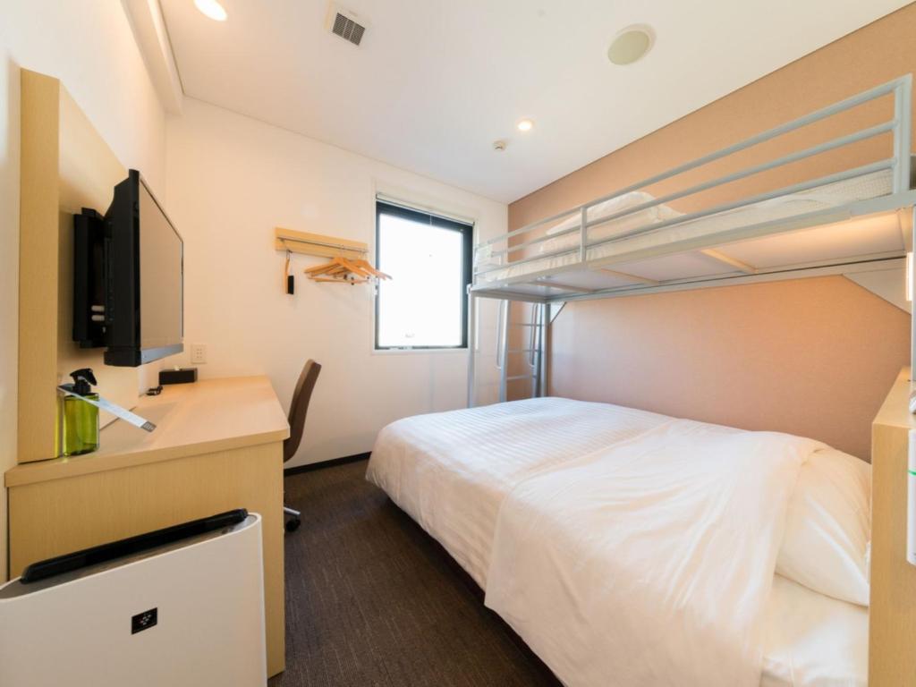 a bedroom with a bed and a tv and bunk beds at Super Hotel Tokyo Kinshicho Ekimae / Vacation STAY 79364 in Tokyo
