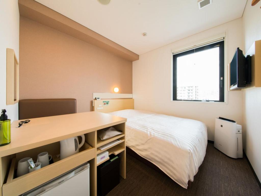 une petite chambre avec un lit et un bureau dans l'établissement Super Hotel Tokyo Kinshicho Ekimae / Vacation STAY 79354, à Tokyo