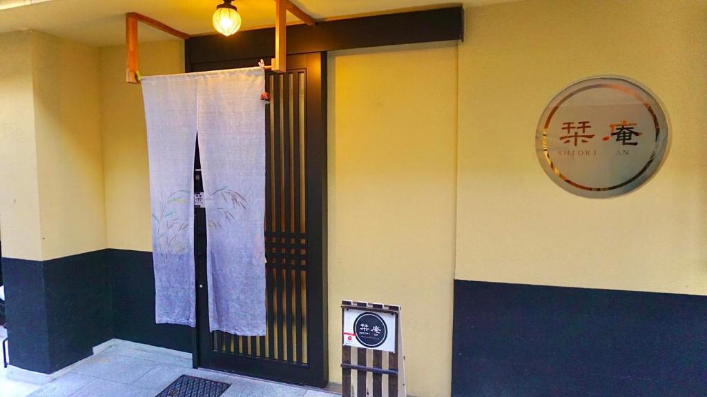 a door in a building with a sign on the wall at ゲストハウス栞庵 in Kyoto