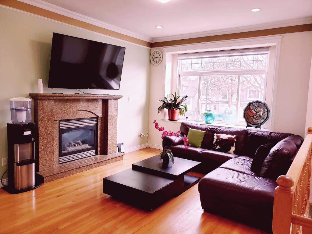 sala de estar con sofá y chimenea en Lisa’s lovely little house en Vancouver