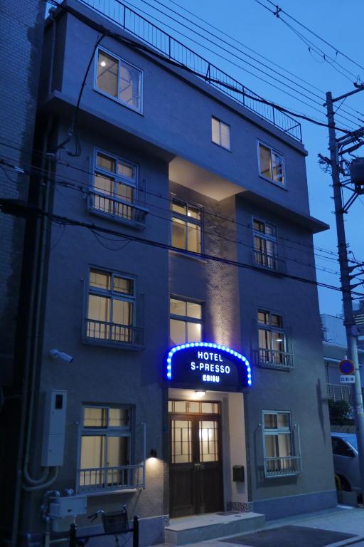 un bâtiment avec un panneau d'hôtel devant lui dans l'établissement Hotel S-Presso Ebisu, à Osaka