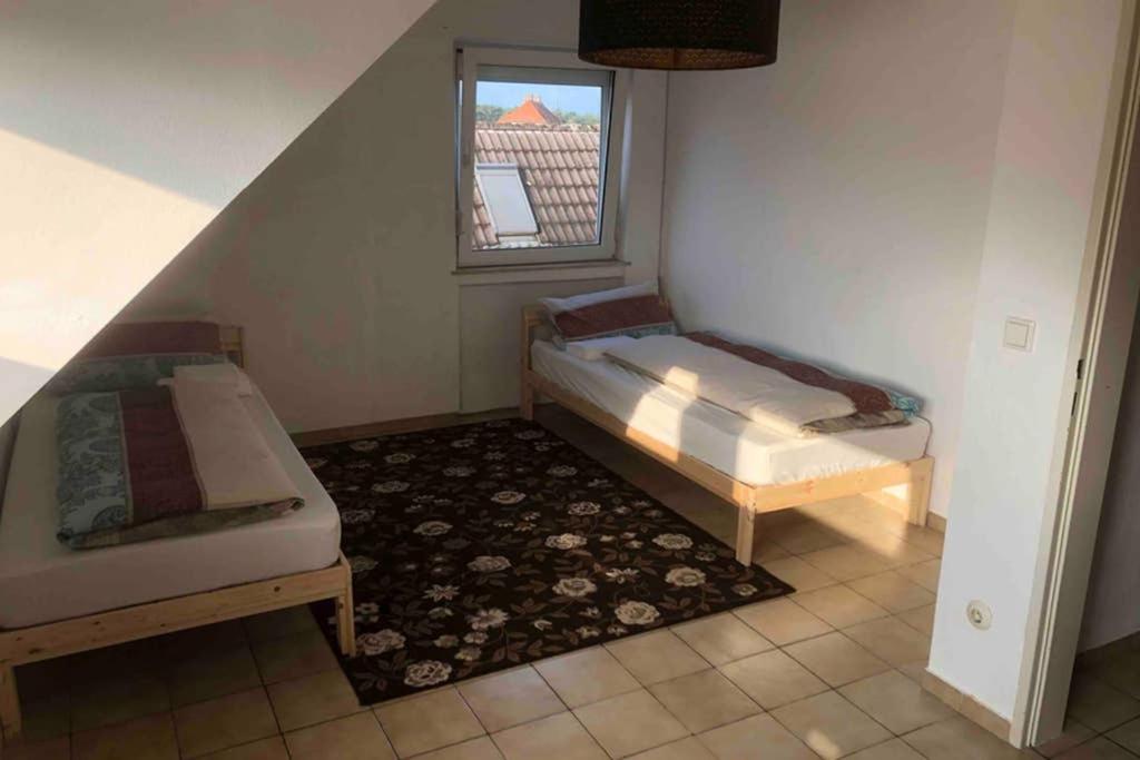 Habitación con 2 camas y ventana en Wohnung 1, en Alzenau