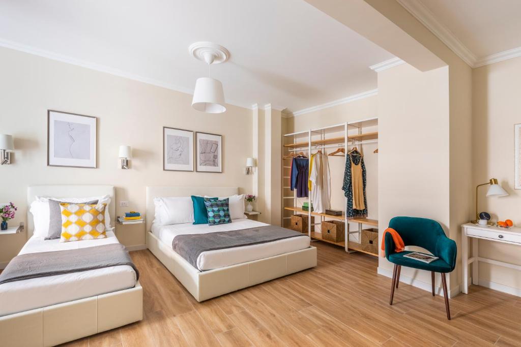 Momo Central Rome 2 في روما: غرفة نوم بسريرين وكرسي ازرق