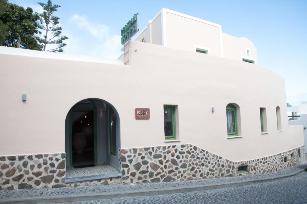 a building with a window on the side of it at Pelican Hotel in Fira