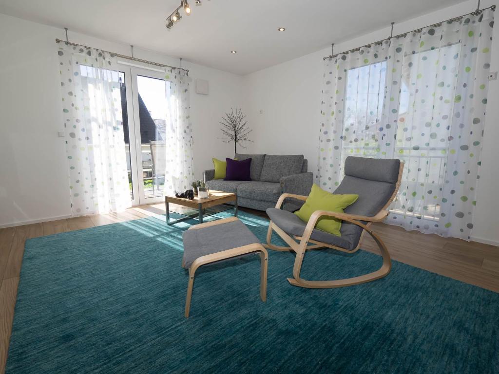 ein Wohnzimmer mit 2 Stühlen und einem Sofa in der Unterkunft 16Lilien Apartmentwohnung in Waiblingen