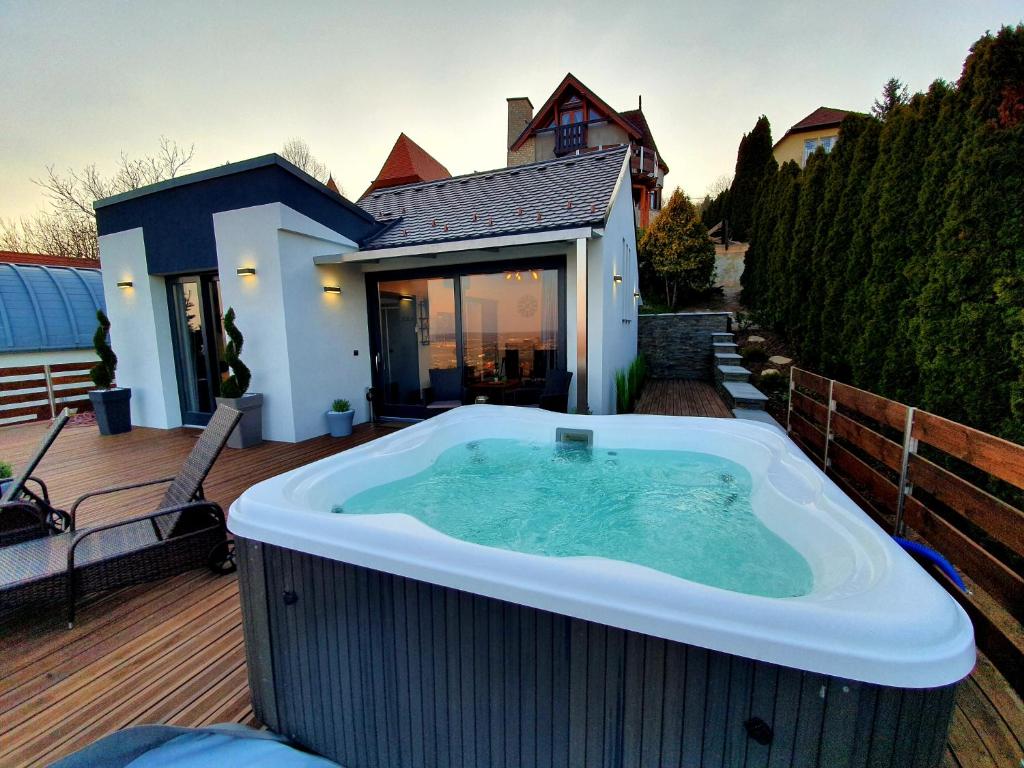 a hot tub on the deck of a house at Bagoly Wellness Apartman in Pécs