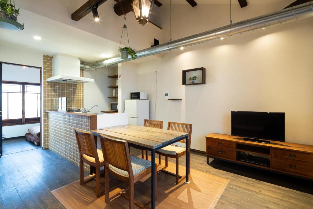 a kitchen and dining room with a table and a television at JISHO-AN in Kyoto