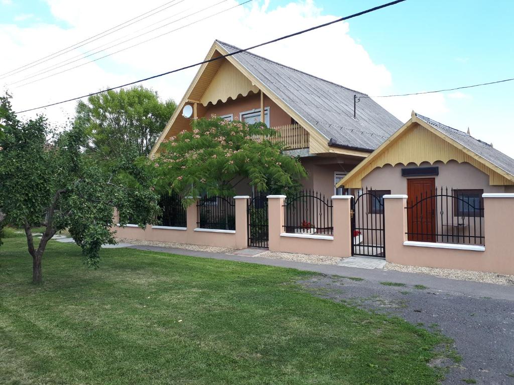 una casa con una valla delante de un patio en Mátyás Vendégház, en Füzesgyarmat