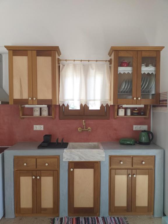 cocina con armarios de madera y encimera azul en Imellos, en Apérathos