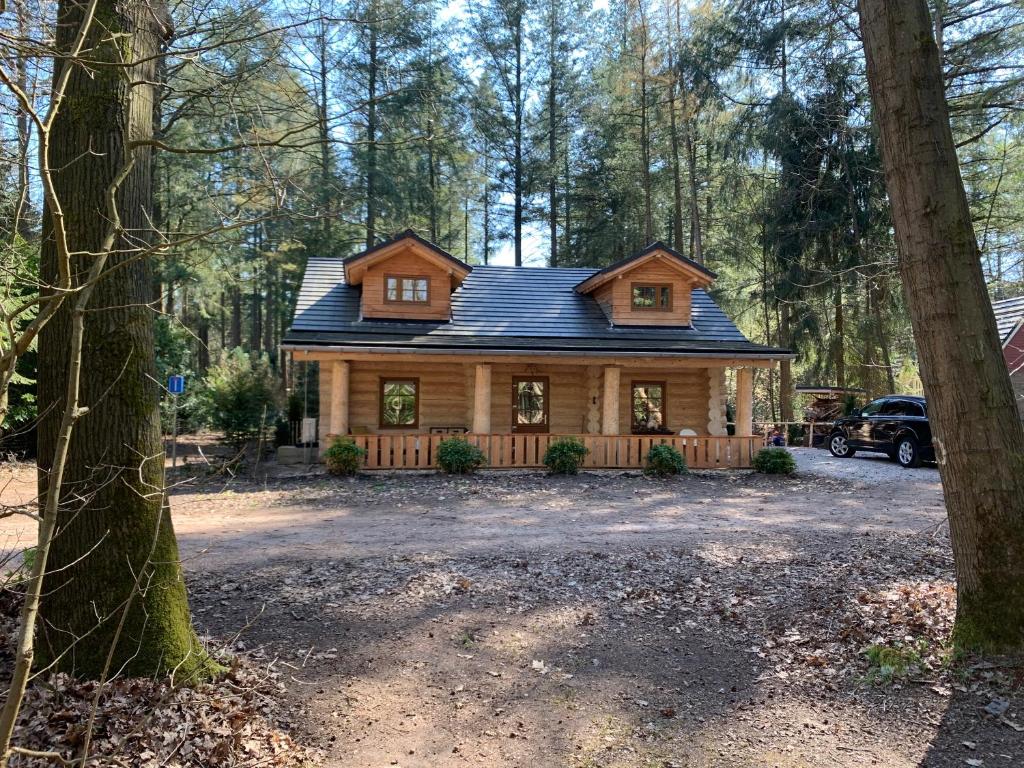 una cabaña de madera en el bosque con entrada en Vakantiehuis de 7 geweien en Emst