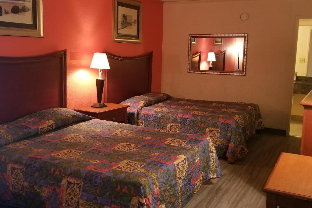 Habitación de hotel con 2 camas y espejo en Best Inn Formerly Known as M Star Hotel, en Chickasaw