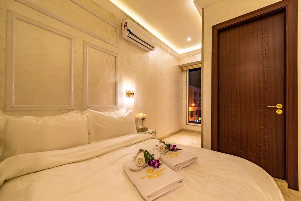 a bedroom with a white bed with two towels on it at AC Residence - Behind Cititel Hotel in Kota Kinabalu