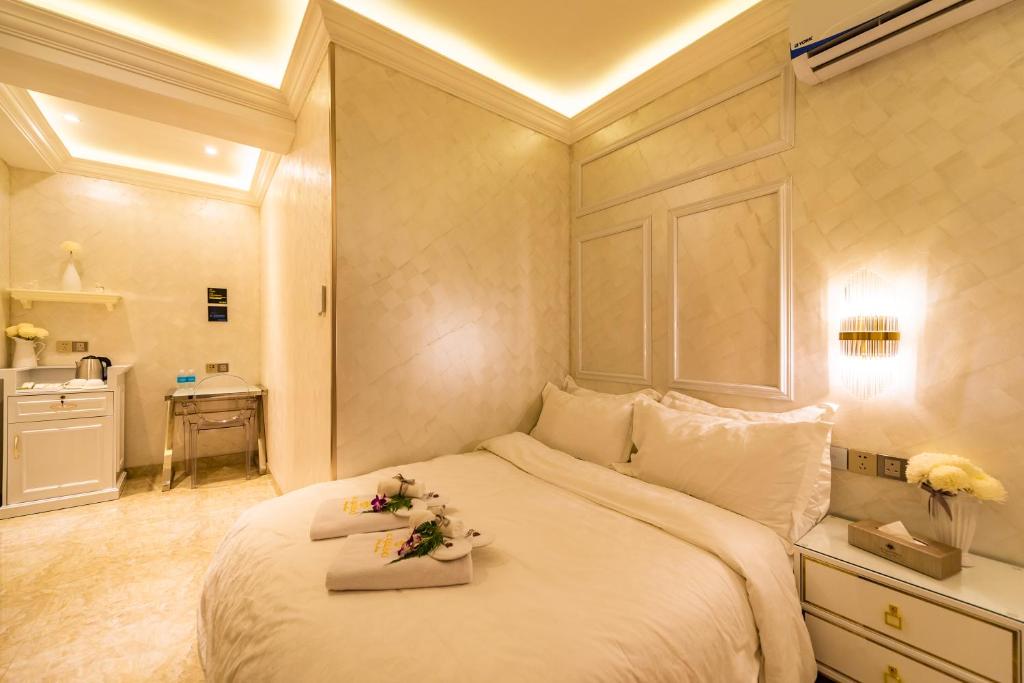 a bedroom with a large white bed with flowers on it at AC Residence - Behind Cititel Hotel in Kota Kinabalu