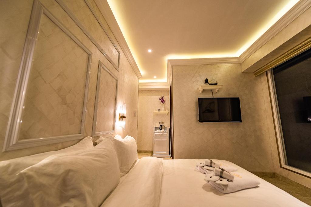 a bedroom with a bed with white sheets and a window at AC Residence - Behind Cititel Hotel in Kota Kinabalu