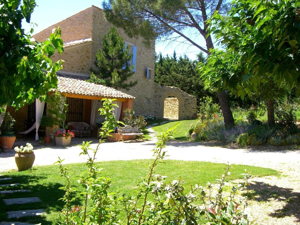 een stenen huis met een tuin op de voorgrond bij Mas de Foncaudette in Lourmarin