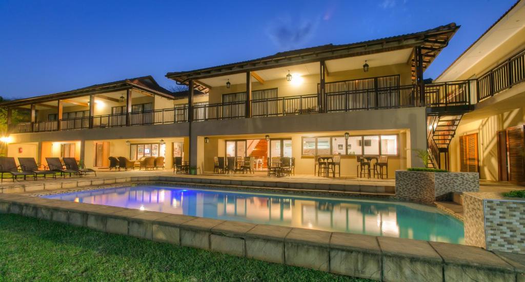 a house with a swimming pool in front of it at Relax Inn in Ballito