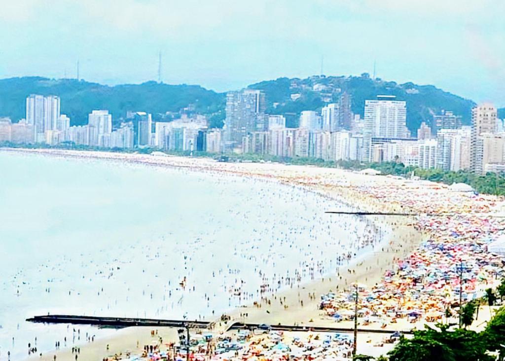 a beach filled with lots of people and buildings at Hotel e Pousada das Goianas in Santos