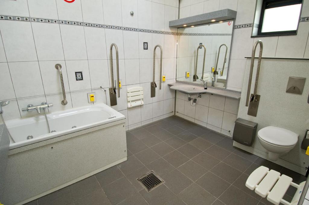 een badkamer met een bad, een toilet en een wastafel bij Camping De Binnenvaart Superior Chalet in Aan de Wolfsberg