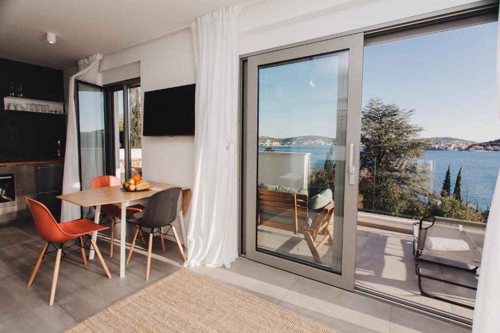 ein Wohnzimmer mit einem Tisch und Stühlen sowie einem großen Fenster in der Unterkunft 3in1 Holiday Home in Rogoznica