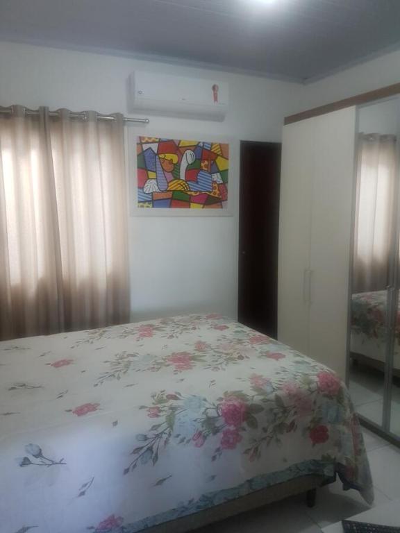 um quarto com uma cama e um quadro na parede em Residencial santana em Feira de Santana